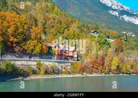 Vista di case colorate lungo il fiume Inn con montagne e un cielo nuvoloso sullo sfondo. Preso a Innsbruck, Austria, il 15 2016 ottobre Foto Stock