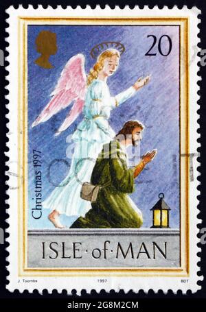 ISOLA DI UOMO - CIRCA 1997: Un francobollo stampato in Isola di Man mostra angelo e pastore, Natale, circa 1997 Foto Stock