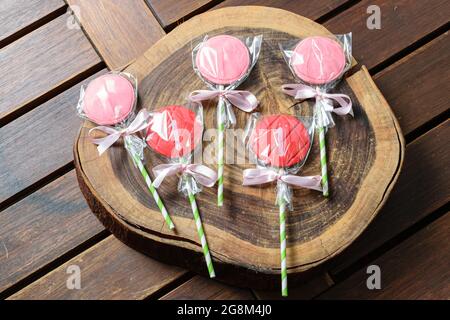 5 lecca di cioccolato alla fragola su tavola di legno. Foto Stock