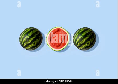 Tre metà di cocomero, isolato e su sfondo estivo azzurro chiaro Foto Stock