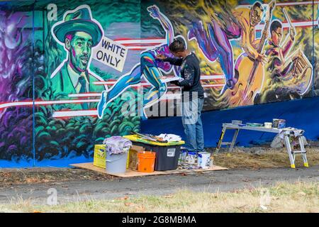 Artista Anthony Joseph dipingere Hogan's Alley, Black History murale su Dunsmuir Viaduct, Vancouver, British Columbia, Canada Foto Stock