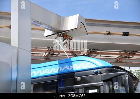 Bus elettrico alla stazione di ricarica durante la ricarica. Trasporti pubblici urbani ecologici del futuro. Foto Stock