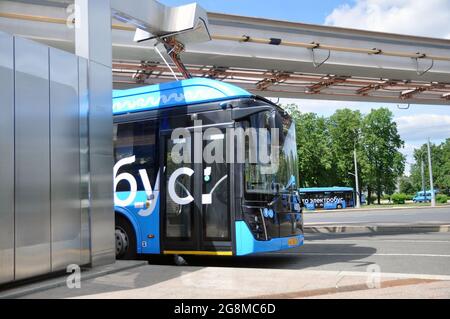 Bus elettrico alla stazione di ricarica durante la ricarica. Trasporti pubblici urbani ecologici del futuro. Foto Stock