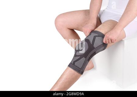 Rinforzo di supporto del ginocchio sulla gamba isolato su sfondo bianco. Ortopedia anatomica. Rinforzi per la fissazione del ginocchio, lesioni e dolore. Orthotics. Piede di Ort Foto Stock