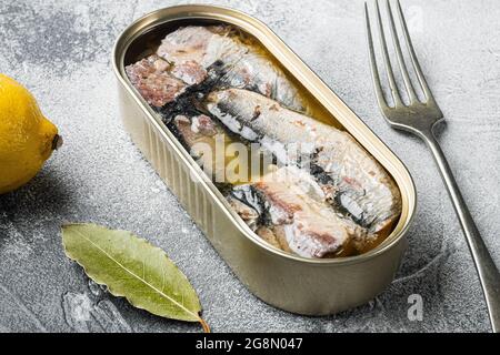 Lattina di sardine in olio d'oliva, su sfondo grigio tavola di pietra Foto Stock