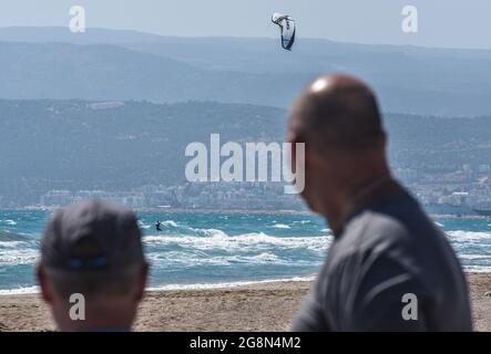 Mersin, Turchia. 21 luglio 2021. La gente guarda una donna kitesurf nel Mediterraneo durante una giornata ventosa nella città costiera di Tasucu a Mersin, Turchia, mercoledì 21 luglio 2021. (Foto di Altan Gocher/GochreImagery/Sipa USA) Credit: Sipa USA/Alamy Live News Foto Stock