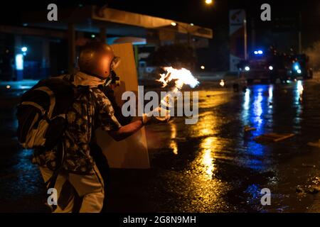 Un dimostratore lancia una bomba molotov su un camion corazzato durante una nuova giornata di proteste anti-governative durante la celebrazione del 211 dell'indipendenza della Colombia dalla spagna, proteste sollevate in scontri in varie città dopo l'intervento della polizia maledetta della Colombia ESMAD, a Medellin, Colombia, il 20 luglio 2021. Foto Stock