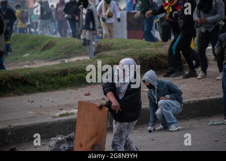 Un dimostratore lancia rocce e depred alla polizia in rivolta in Colombia durante una nuova giornata di proteste anti-governative durante la celebrazione del 211 dell'indipendenza della Colombia dalla spagna, proteste sollevate in scontri in varie città dopo l'intervento della polizia malata della Colombia ESMAD, a Bogotà, Colombia, il 20 luglio 2021. Foto Stock