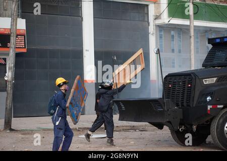 Un membro della prima linea getta il suo scudo su un camion corazzato durante un nuovo giorno di proteste anti-governative durante la celebrazione del 211 dell'indipendenza della Colombia dalla spagna, proteste sollevate in scontri in varie città dopo l'intervento della polizia malata della Colombia ESMAD, a Bogotà, Colombia, il 20 luglio 2021. Foto Stock