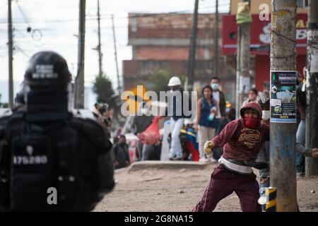 Un dimostratore getta rocce e depree alla polizia durante una nuova giornata di proteste anti-governative durante la celebrazione del 211 dell'indipendenza della Colombia dalla spagna, proteste sollevate in scontri in varie città dopo l'intervento della polizia malata della Colombia ESMAD, a Bogotà, Colombia, il 20 luglio 2021. Foto Stock