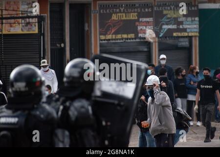 Un dimostratore getta rocce e depree alla polizia durante una nuova giornata di proteste anti-governative durante la celebrazione del 211 dell'indipendenza della Colombia dalla spagna, proteste sollevate in scontri in varie città dopo l'intervento della polizia malata della Colombia ESMAD, a Bogotà, Colombia, il 20 luglio 2021. Foto Stock