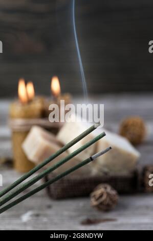 Ambiente SPA rustico con bastoncini d'incenso fumanti, sapone naturale d'oliva e candele al miele Foto Stock