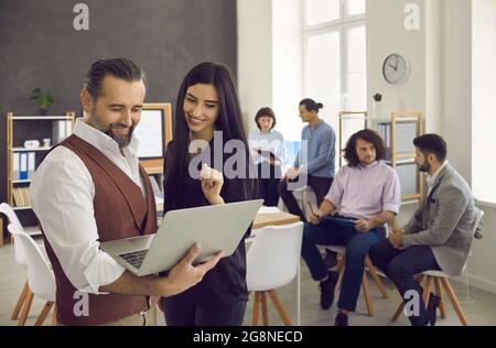 Gruppo di uomini d'affari che lavorano e comunicano insieme in ufficio creativo Foto Stock