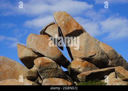 Primo piano dei massi a forma di piramide dell'isola di granito contro il cielo blu Foto Stock