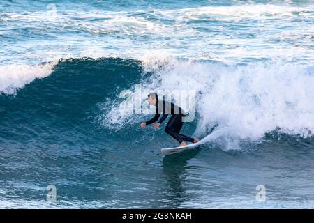 Australia maschile surf al largo della costa di Avalon Beach a Sydney in un giorno d'inverno, Sydney, NSW, Australia Foto Stock