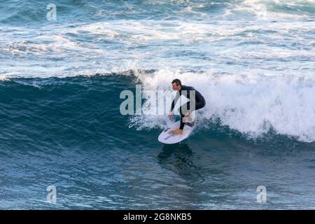 Australia maschile surf al largo della costa di Avalon Beach a Sydney in un giorno d'inverno, Sydney, NSW, Australia Foto Stock
