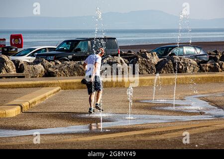 The Battery, Morecambe, Lancashire, Regno Unito. 22 luglio 2021. Il runner della mattina presto si avvantaggia del Kids Splash Park sulla Promenade per sciogliare fuori del credito: Notizie dal vivo di PN/Alamy Foto Stock