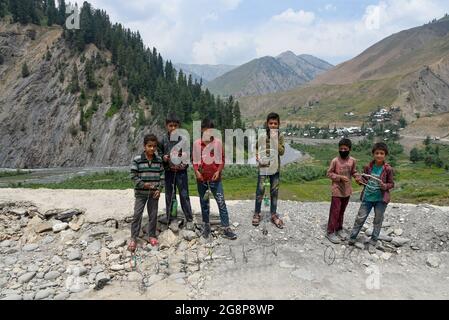 Bandipora, India. 22 luglio 2021. I bambini posano per una foto davanti alle montagne vicino al confine recintato a Tulail, Gurez.Gurez si trova lungo la LOC (linea di controllo) nella parte settentrionale del Kashmir. Le persone a Gurez sono i Dard-Shins con la loro ascendenza che vivono a Gilgit in Pakistan. Le caratteristiche e l'abbigliamento del Dard sono simili al Kashmiris. Credit: SOPA Images Limited/Alamy Live News Foto Stock