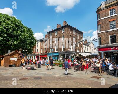 La trafficata Parliament Street e l'ingresso al mercato di Shambles in una giornata estiva nello York Yorkshire Inghilterra Foto Stock