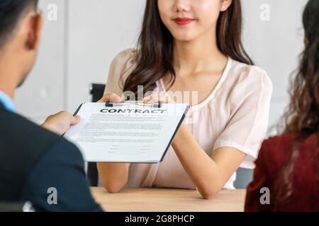 Senior Asian Manager inviando il documento di contratto alla giovane donna asiatica laureata dopo l'intervista di affare con movimento positivo in sala riunioni, Business Foto Stock