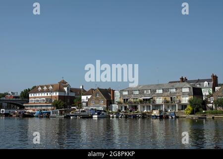 vista estiva sul fiume tamigi dai giardini di canbury verso le case e le barche ormeggiate di hampton wick, a sud-ovest di londra, inghilterra Foto Stock