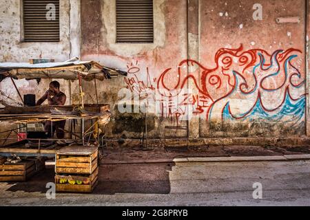 Havana, Cuba, luglio 2019, venditore di frutta da graffiti in una strada della parte più antica della città Foto Stock
