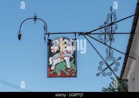 George House segno pub su una staffa ornata in ferro battuto nel villaggio Hampshire di Hambledon con St George e il drago, Inghilterra, Regno Unito Foto Stock