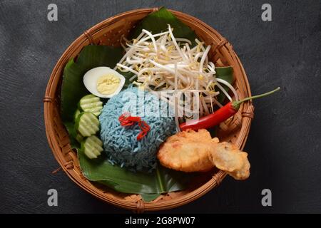 Nasi kerabu o nasi ulam, popolare Malay piatto di riso. Colore blu del riso derivante dai petali di butterfly-pea fiori. Tradizionale cibo malese, Foto Stock