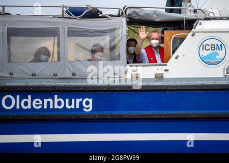 Nordsee, Germania. 22 luglio 2021. Björn Thümler,(CDU, r), Ministro della Scienza della bassa Sassonia, Waves a bordo della nave di ricerca 'Otzum' che naviga tra Neuharlingersiel e Spiekeroog. Thümler sta visitando la rete di ricerca costiera. Il progetto mira a studiare come la protezione costiera e la protezione degli ecosistemi possano essere riconciliate e funzionare anche a lungo termine. A tal fine, i ricercatori utilizzano i cosiddetti laboratori reali. Credit: Sina Schuldt/dpa/Alamy Live News Foto Stock
