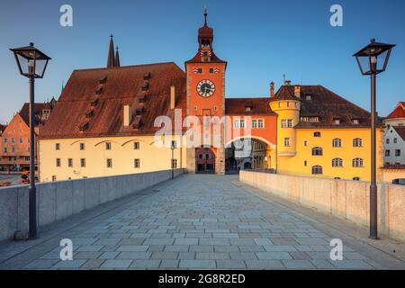 Regensburg, Germania. Immagine del paesaggio urbano di Ratisbona, Germania con il Ponte Vecchio di pietra sul Danubio e la Cattedrale di San Pietro all'alba estiva. Foto Stock