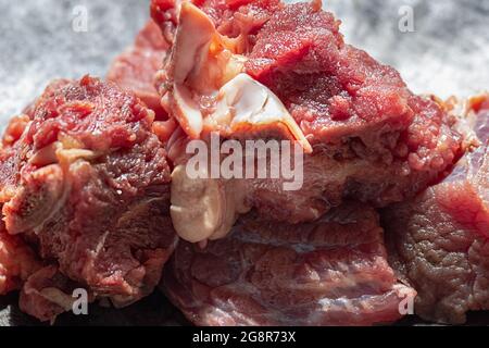 Carne rossa cruda preparandosi per il cuoco in cucina primo piano Foto Stock