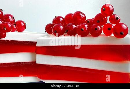 Due deliziosi pezzi di panna rossa e bianca. Torta decorata con viburnum Foto Stock