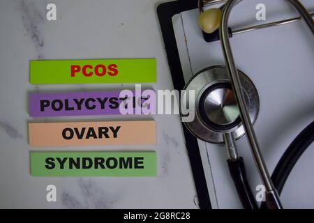 POCS - sindrome dell'ovaio policistico scrivere su note appiccicose isolate su tavola di legno. Foto Stock