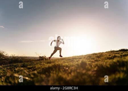 Donna attiva inriconosciuta con abiti sportivi che corrono nel parco e allenarsi la sera. Foto Stock