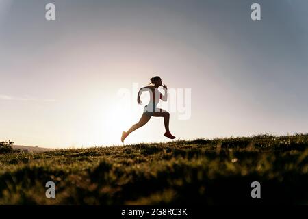 Donna attiva inriconosciuta con abiti sportivi che corrono nel parco e allenarsi la sera. Foto Stock