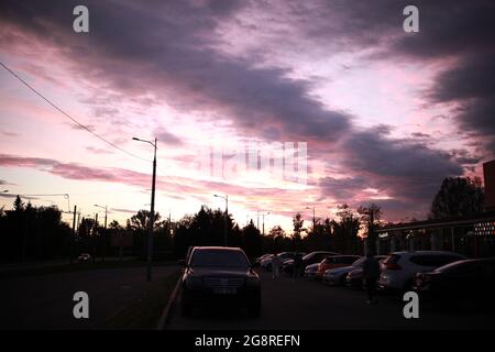 Un tramonto su una strada cittadina piena di traffico Foto Stock