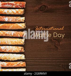 Giornata internazionale di waffle. Cibo, banner di congratulazioni con cialde su sfondo di legno con Inspiration National waffle Day. Saporito, sudore Foto Stock