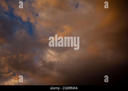 Cielo serale pittoresco sulla città dopo una tempesta di tugore. Nuvole di tuoni colorate nella luce del tramonto. Foto Stock