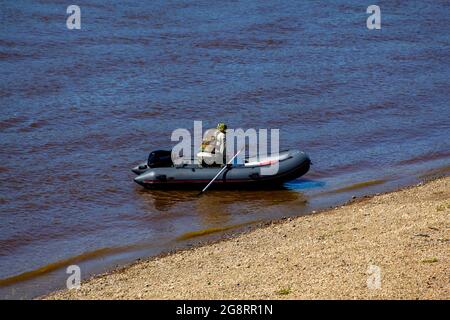 Motoscafo con un uomo in acque costiere. Turismo con trasporto in acqua. Caccia e pesca su una barca a motore. Foto Stock