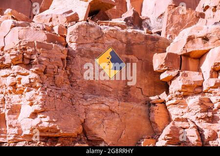 Attenzione al segno delle rocce che cadono affisso su una scogliera di rocce rosse nello Utah Foto Stock