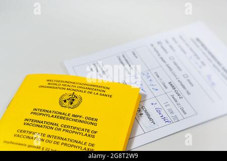 Certificato internazionale giallo di vaccinazione e scheda di registrazione bianca per l'immunizzazione con coronavirus SARS-COV-2 Covid-19 con mRNA covid-19 Vac Biontech Foto Stock