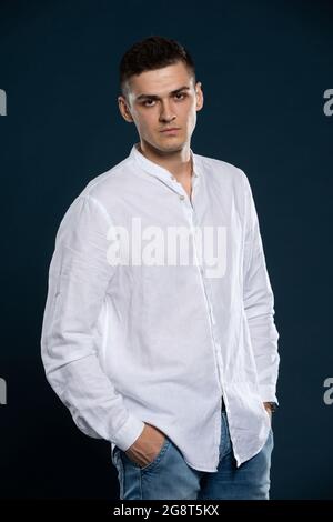 Ritratto di un giovane che indossa una camicia bianca a manica lunga. Un aspetto determinato. Foto Stock