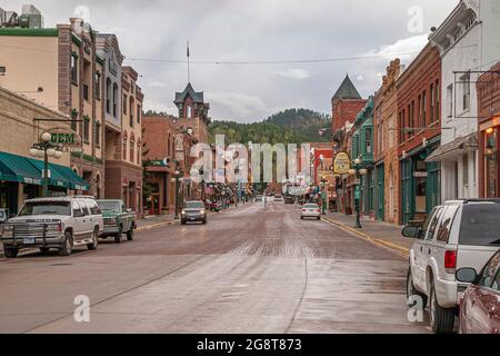 Deadwood, Stati Uniti d'America - 31 maggio 2008: Main Street centro. Guardando a sud, si mostrano edifici storici per gli affari su entrambi i lati con la collina boschiva alla fine sotto la r Foto Stock