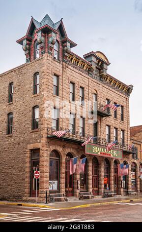 Deadwood, Stati Uniti d'America - 31 maggio 2008: Main Street centro. Hotel storico in mattoni beige e pietra, decorato con bandiere americane. Torre sportiva Foto Stock