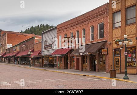 Deadwood, Stati Uniti d'America - 31 maggio 2008: Main Street centro. Godlberg e Gold Dust commerci in fila con altri commerci sotto cielo piovoso. bri tradizionale Foto Stock