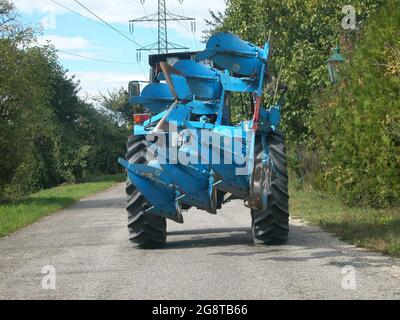 Trattore con aratro su strada stretta , Austria Foto Stock