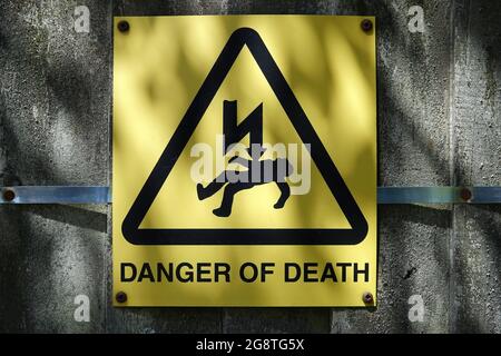 Primo piano di "Danger of Death" con un cartello di avvertimento per elettrocuzione montato sulla parete in cemento Foto Stock