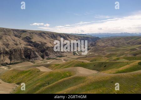 Le vette e le praterie montane sono sotto le nuvole bianche. Sparato a Xinjiang, Cina. Foto Stock