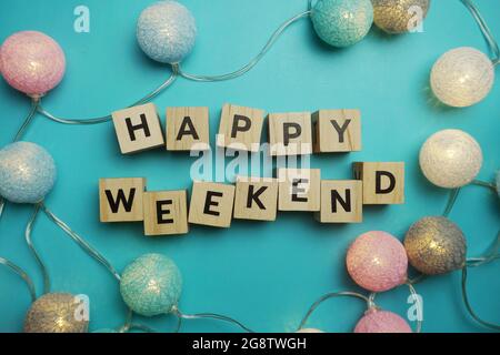 Lettera alfabetica Happy Weekend con pallina di cotone LED decorata su sfondo blu Foto Stock