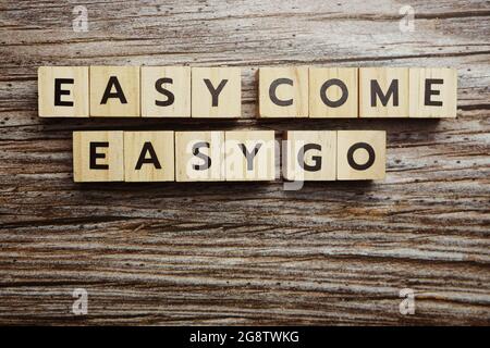 Lettere alfabetiche Easy come Easy Go su sfondo di legno Foto Stock